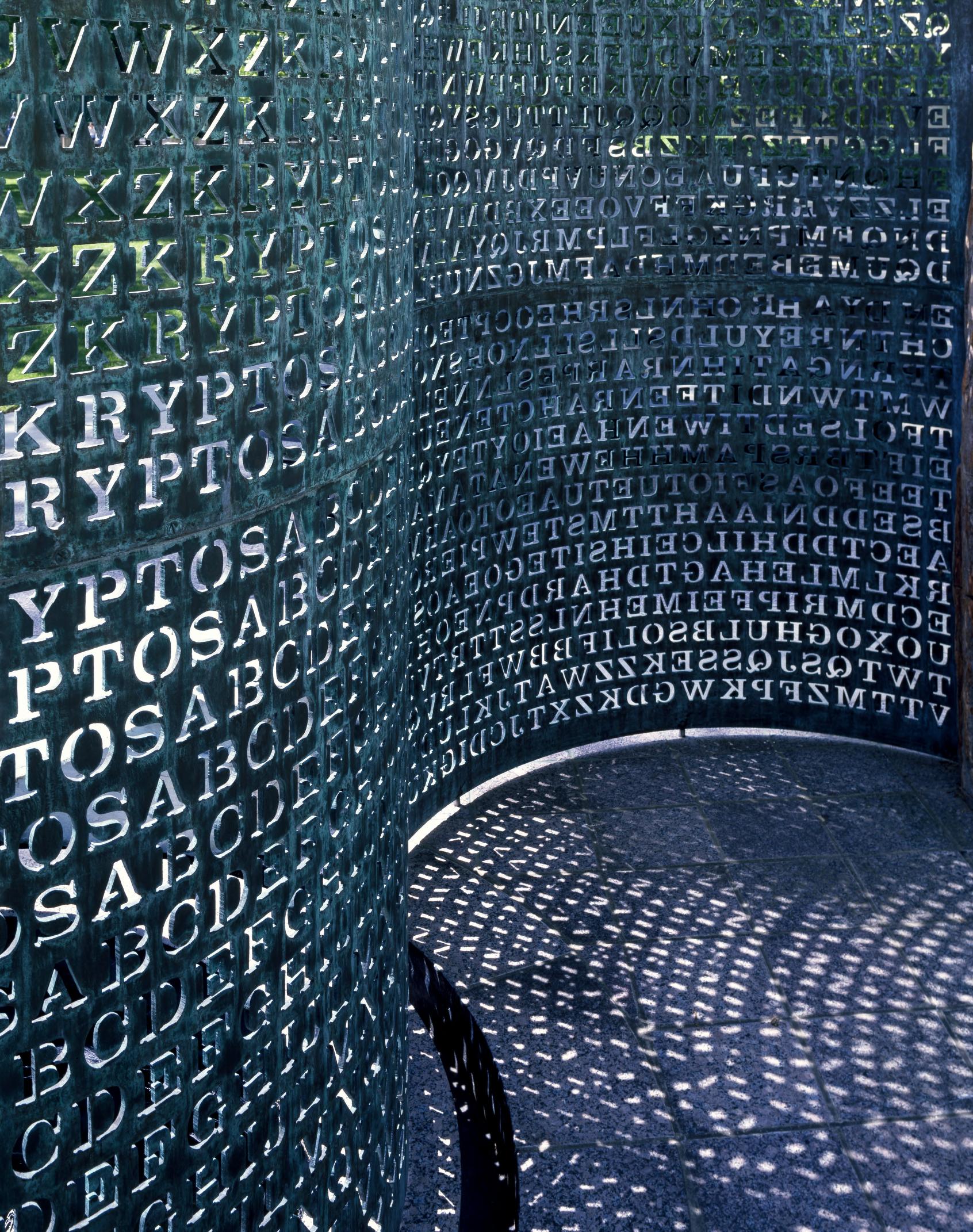 The Kryptos sculpture by Jim Sanborn in the courtyard of the CIA's Original Headquarters Building, Langley, Virginia. A curving copper plate, just under twelve feet tall, with about 1,800 letters cut out of it arranged into four ciphertexts. Photograph by Carol M. Highsmith, Library of Congress, no known restrictions on publication.